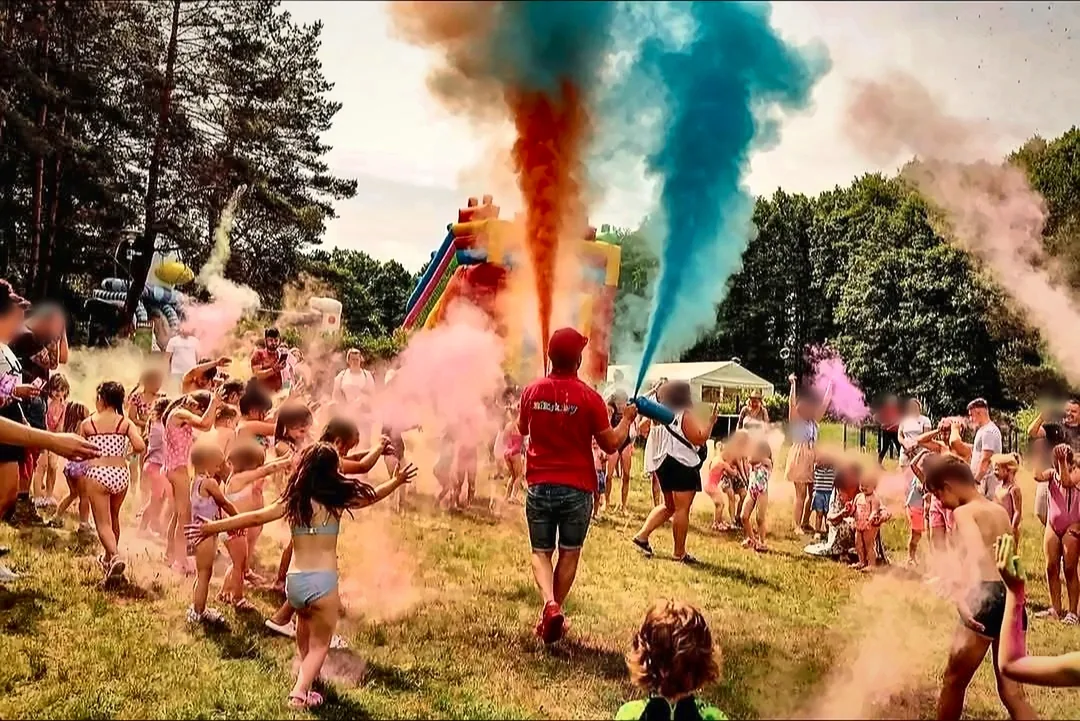 Dzieci w chmurze kolorowych proszków podczas festiwalu kolorów Holi